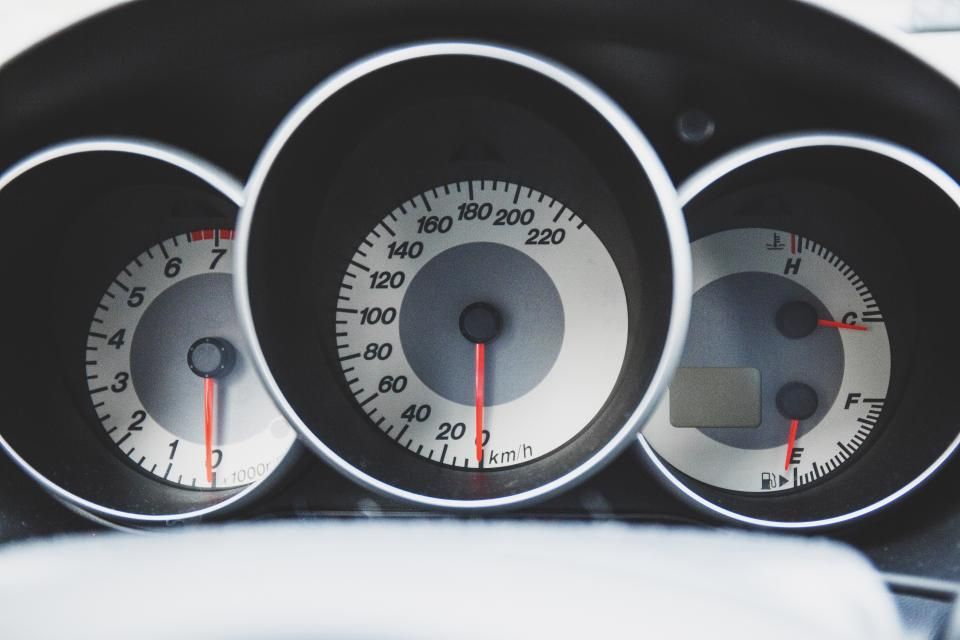 Compteurs ronds à fond blanc et aiguilles rouges d'une voiture de sport
