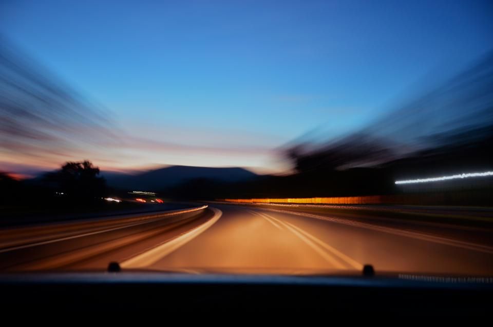 Route de montagne au crépuscule, vue depuis le volant d'une voiture lancée